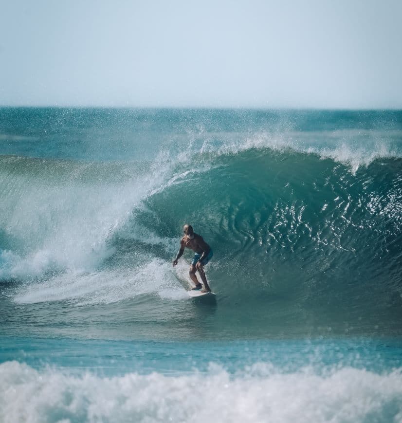 Surfers catching waves at sunset